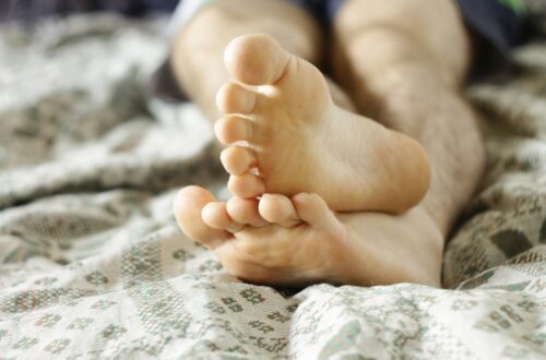 Hombre pensativo sentado en una cama desordenada, reflejando intimidad después de los 30