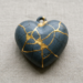 Heart-shaped pendant with gold repairs on cracked surface